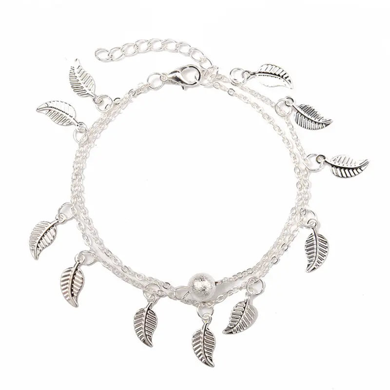 Silver bracelet with leaf charms on a white background