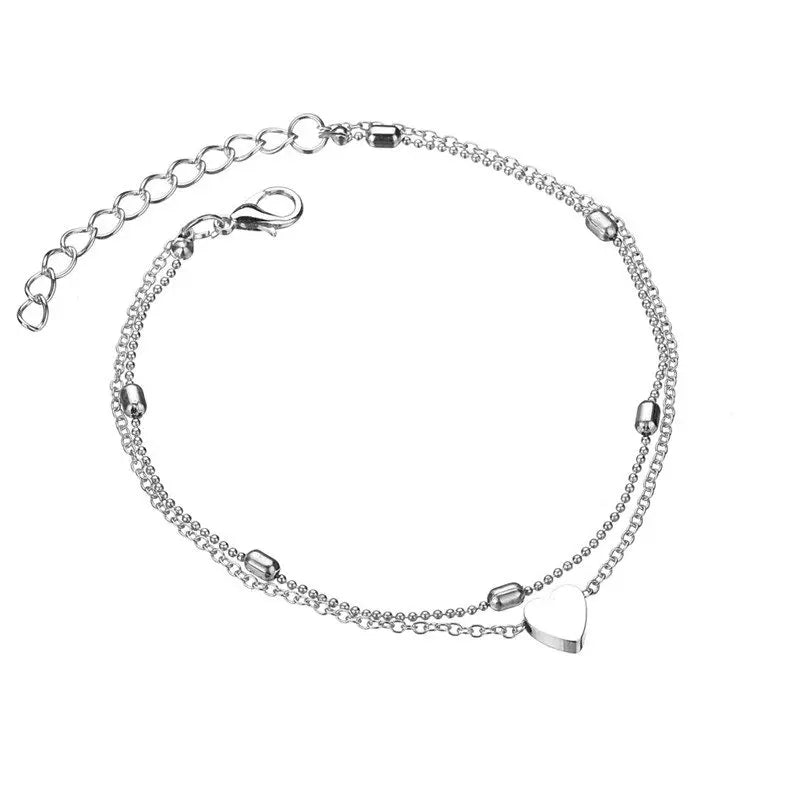 Silver bracelet with heart charm on a white background