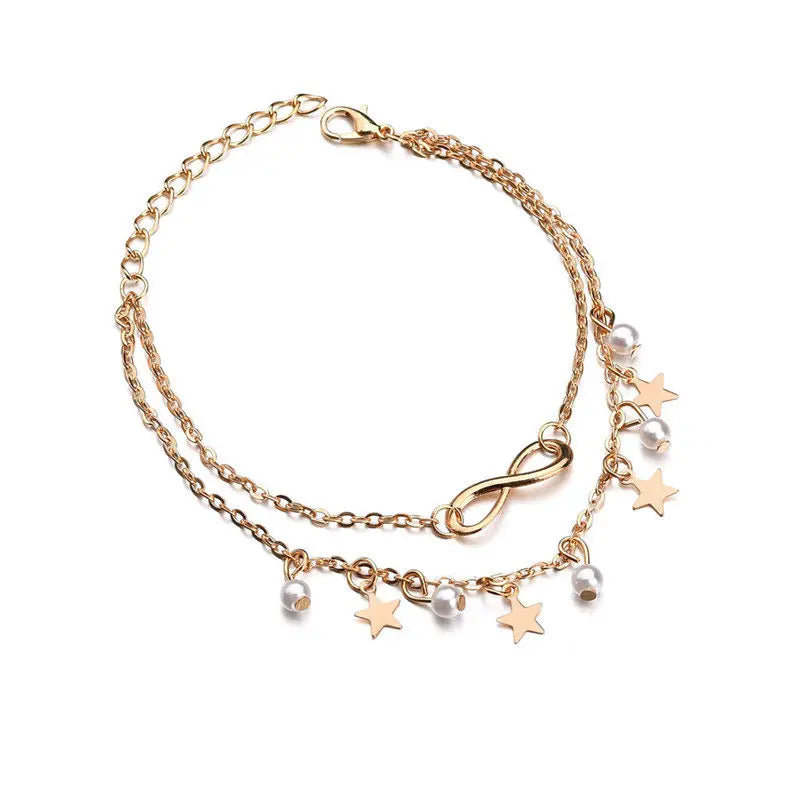 Gold bracelet with star and infinity charm on a white background