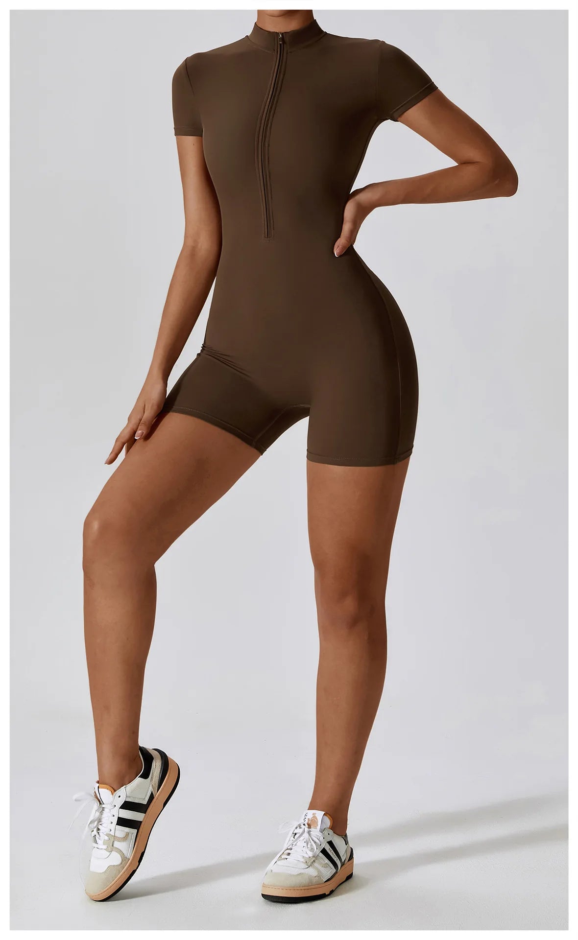 Person wearing a brown bodysuit with white sneakers on a light gray background