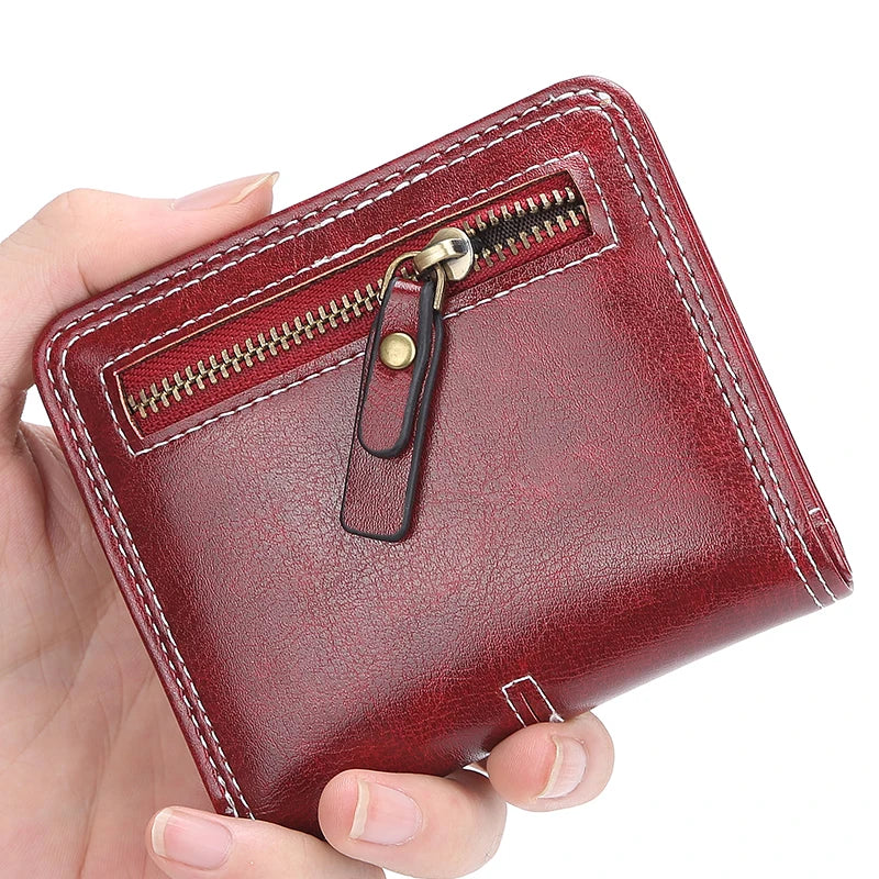Red leather wallet with a zipper held by a hand on a white background