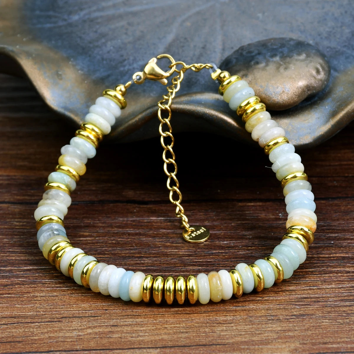 Bracelet with gold and white beads on a wooden surface