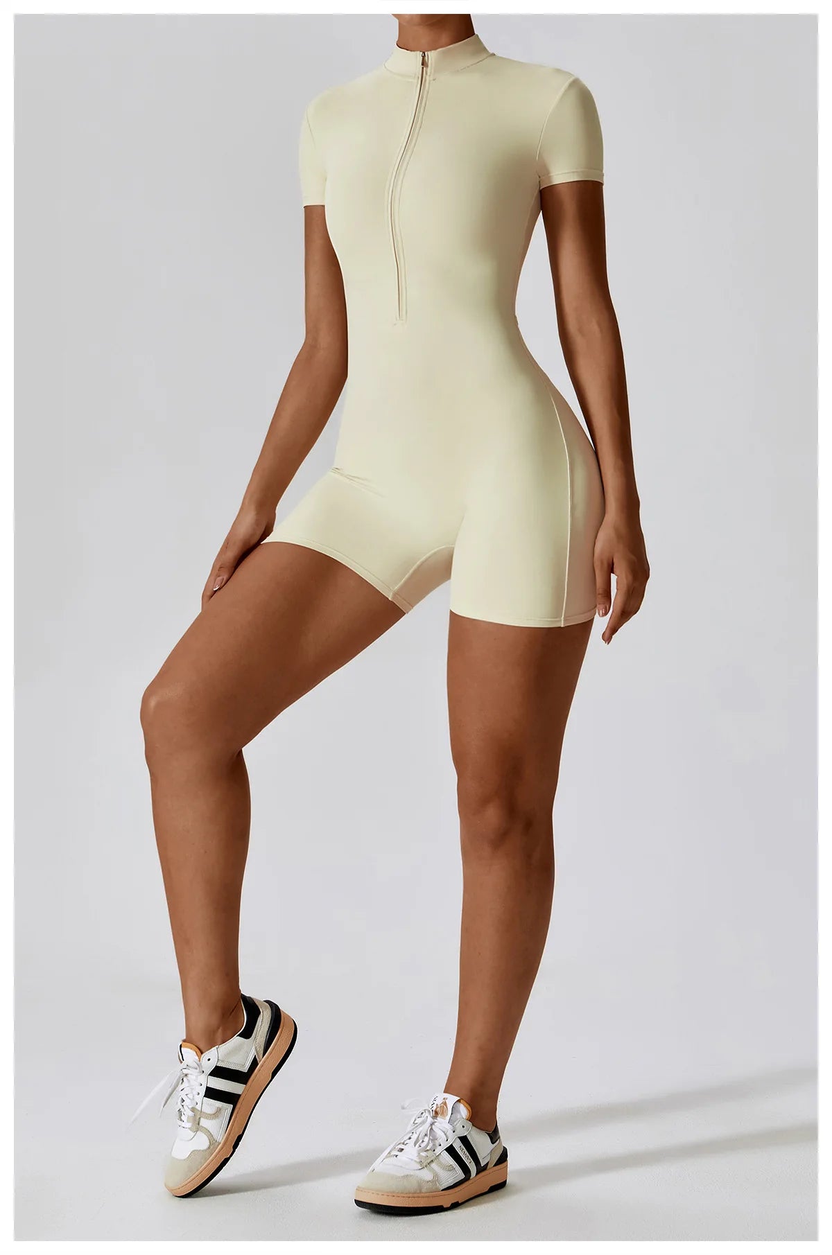 Person wearing a light yellow bodysuit on a plain background