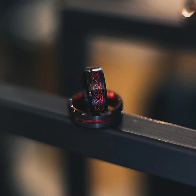 Close-up of a black ring with red detailing on a metallic surface.