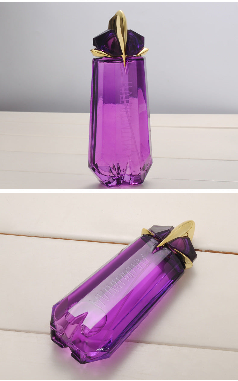 Purple gemstone-shaped bottle with gold accents on a light gray background