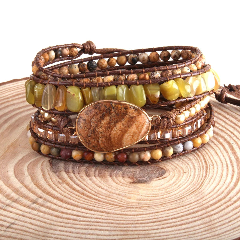 Stack of beaded bracelets with a large brown stone on a wooden surface