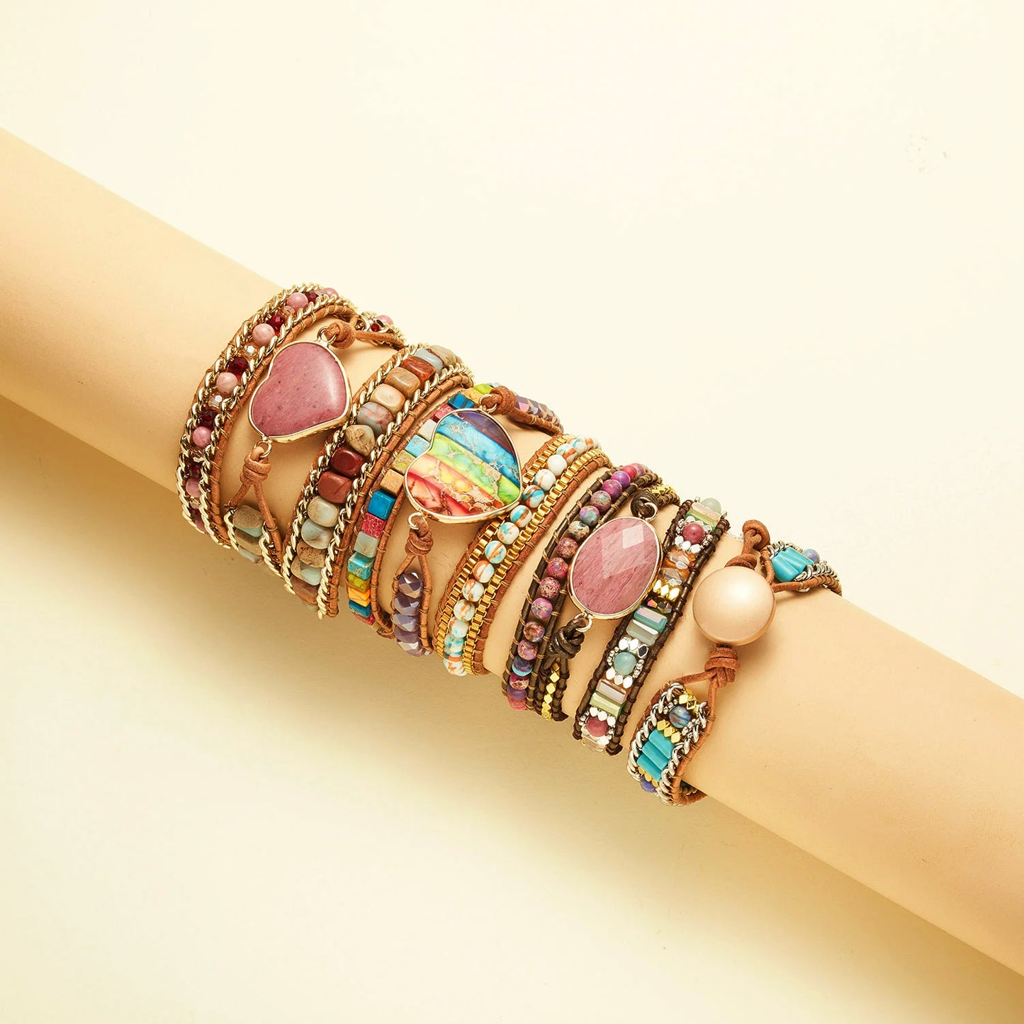 Multicolored beaded bracelets on a beige arm against a beige background