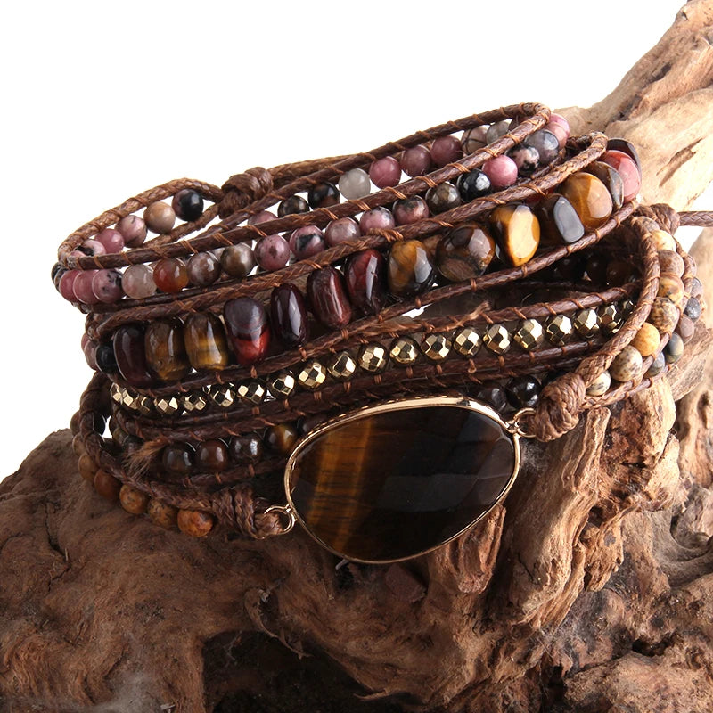 Multistrand beaded bracelet with stones and gold accents on a wooden surface