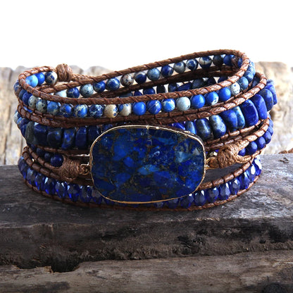 Multistrand bracelet with blue beads and a large blue stone on a wooden surface