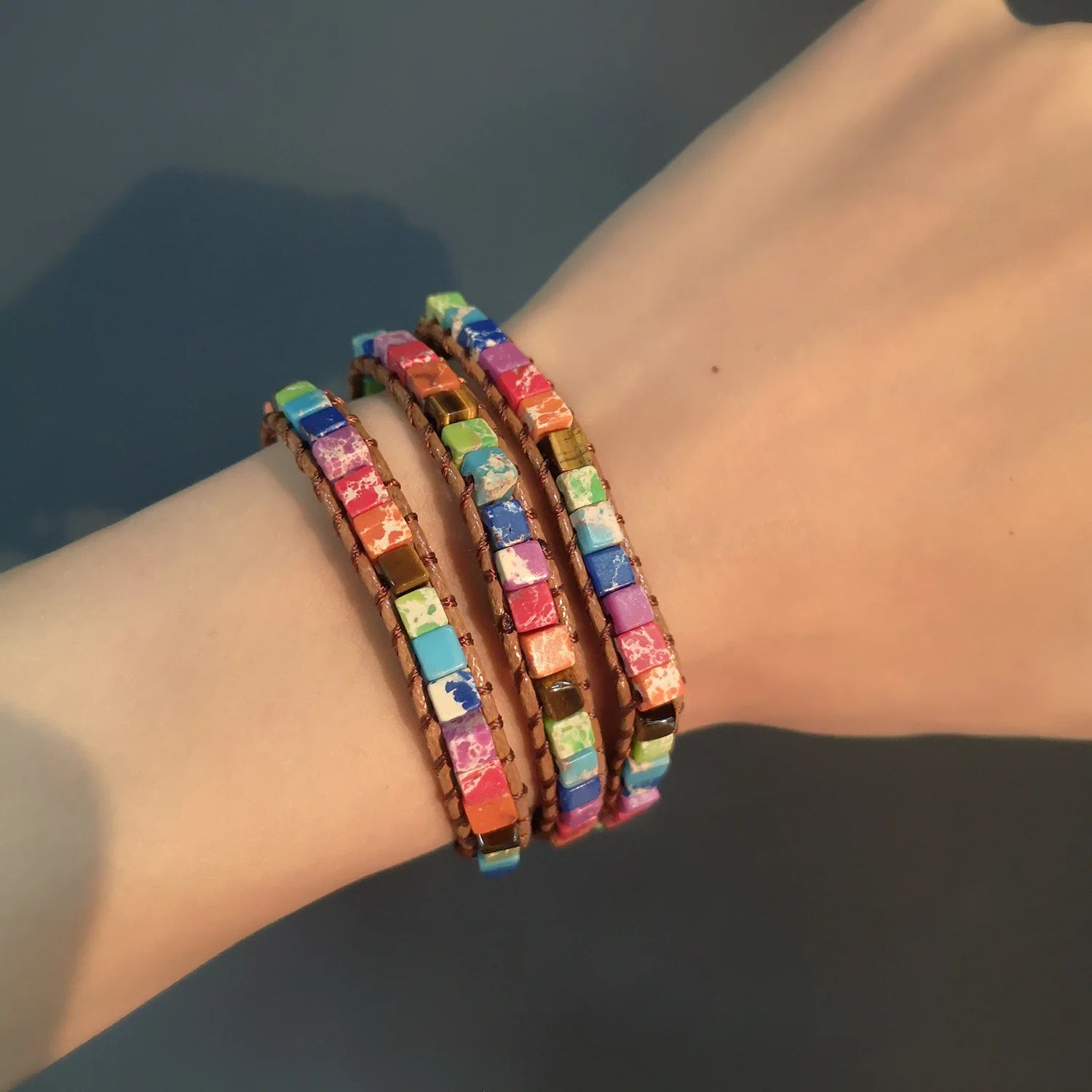 Colorful beaded bracelet on a wrist with a dark background