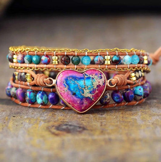 Multistrand bracelet with a heart-shaped gemstone on a textured surface