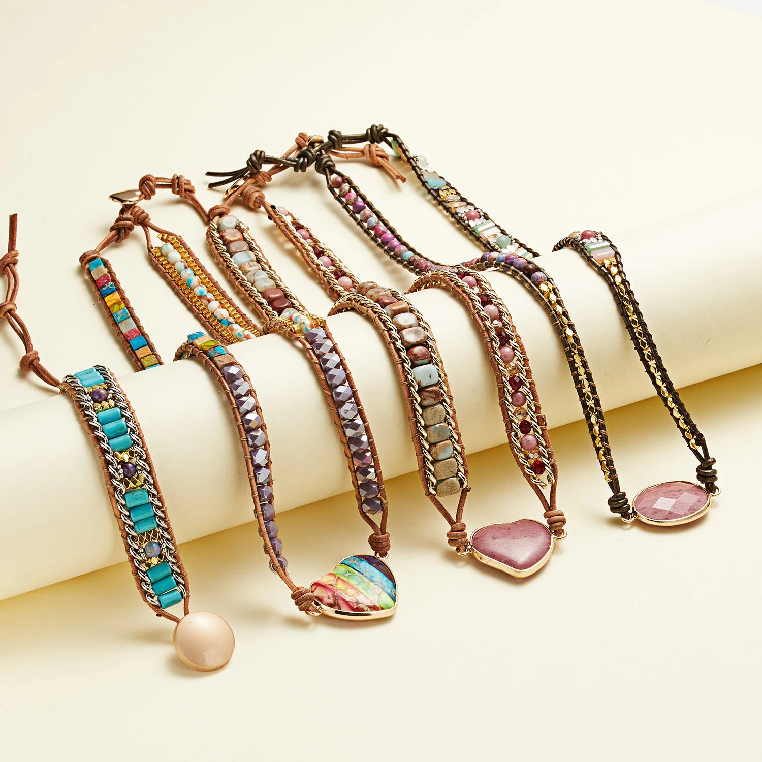 Set of colorful bracelets with various beads and stones on a light background