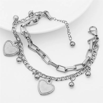 Silver bracelet with heart charms on a white background
