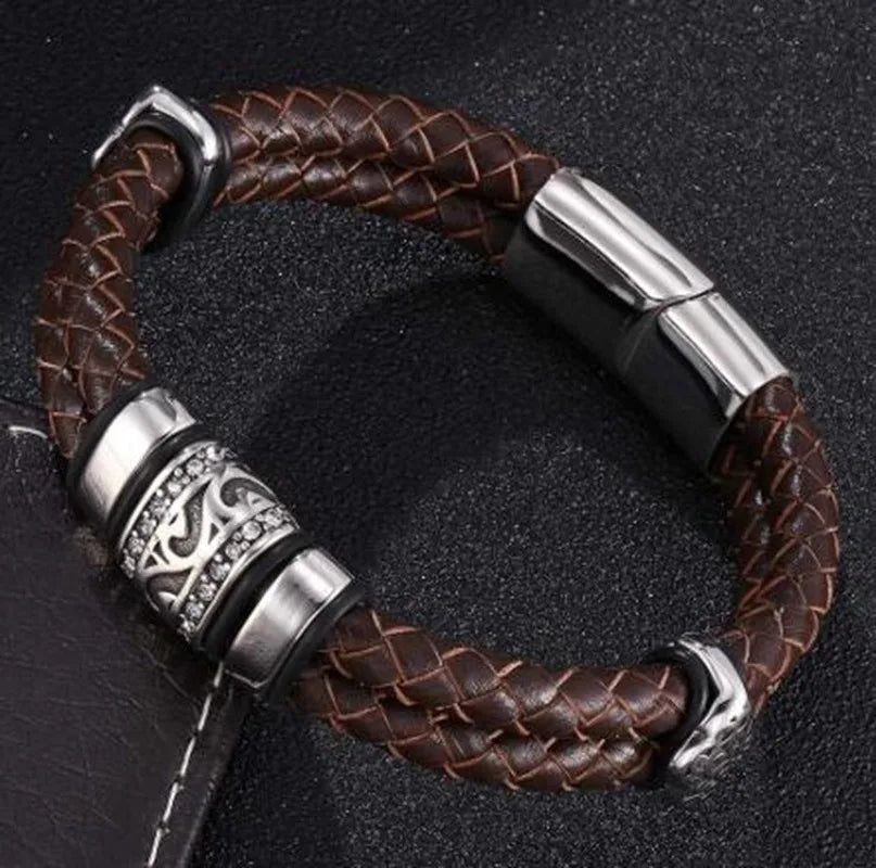 Brown braided leather bracelet with silver metal clasp on a dark background