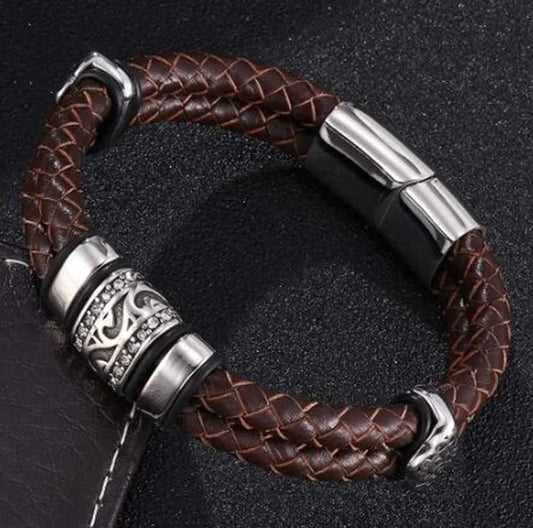 Brown braided leather bracelet with silver metal clasp on a dark background