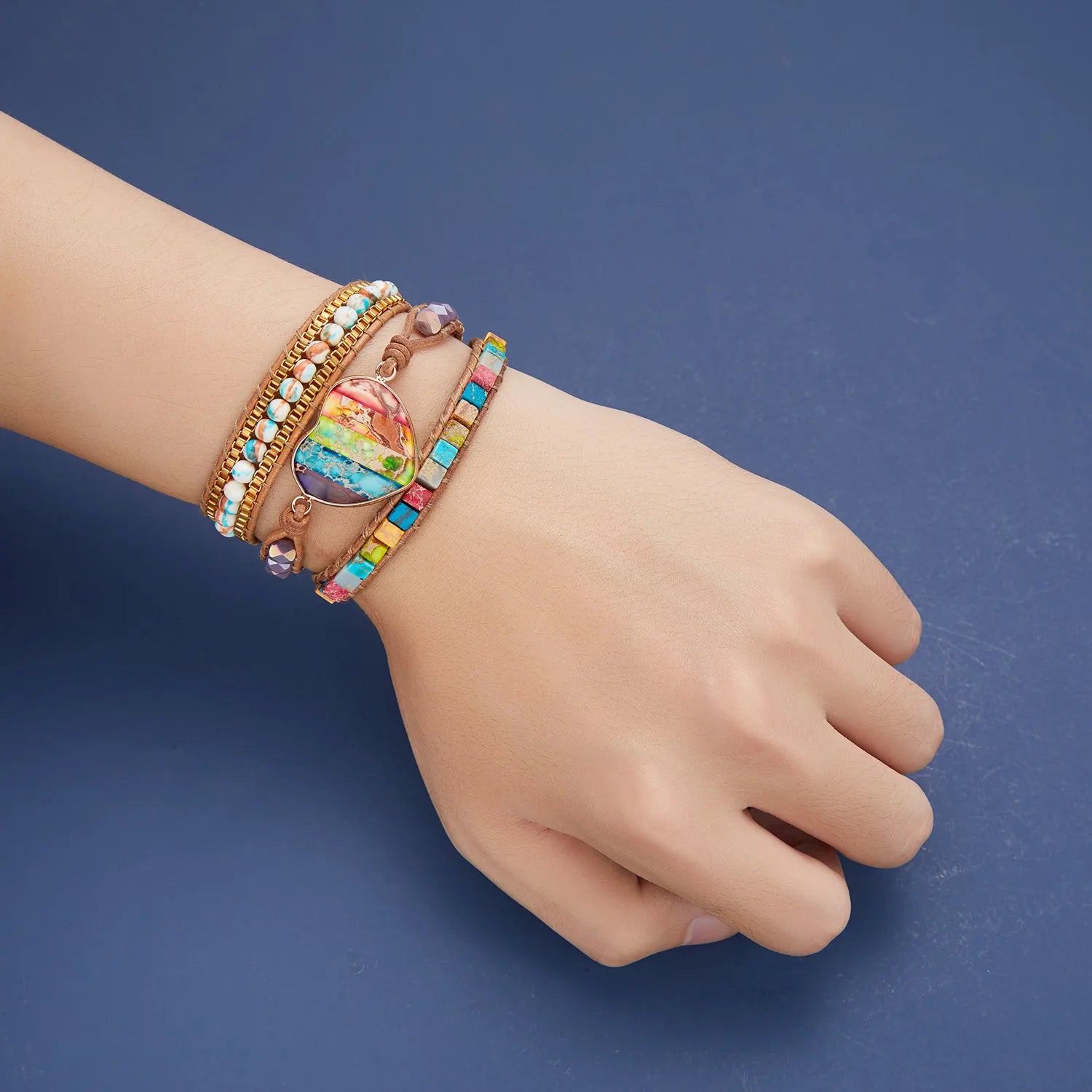Hand wearing colorful bracelets on a blue background