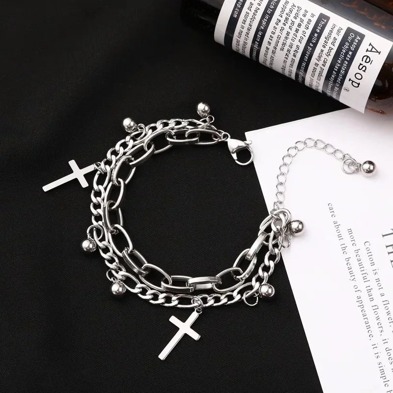 Silver chain bracelet with cross charms on a black and white background