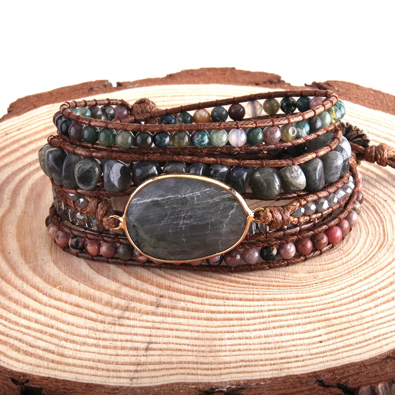 Stack of beaded bracelets with a stone focal point on a wooden surface