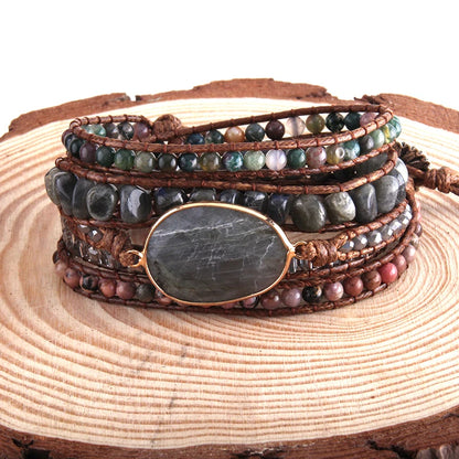 Stack of beaded bracelets with a stone focal point on a wooden surface