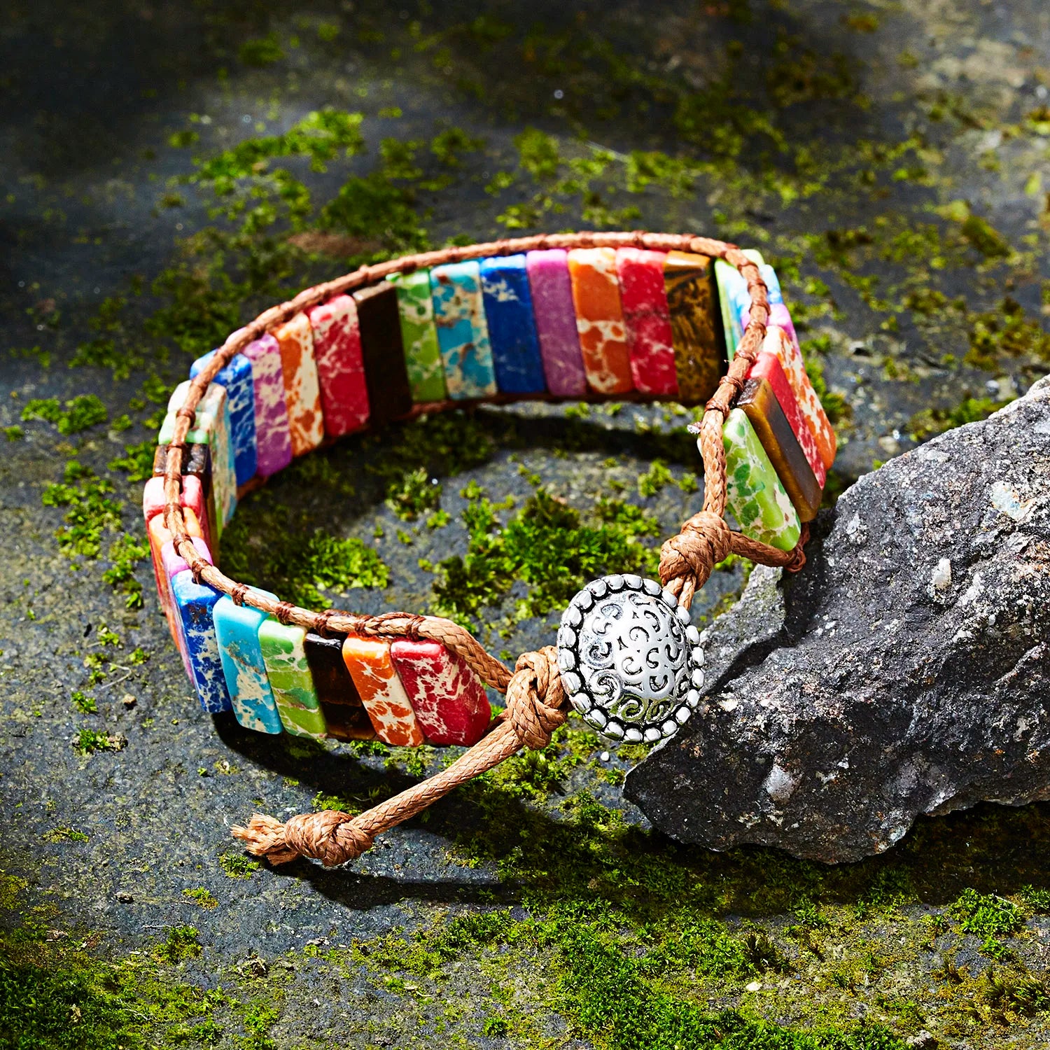 Colorful beaded bracelet with a decorative clasp on a stone surface
