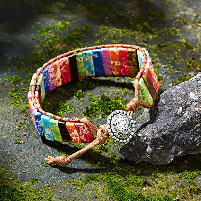 Colorful beaded bracelet with a decorative clasp on a stone surface