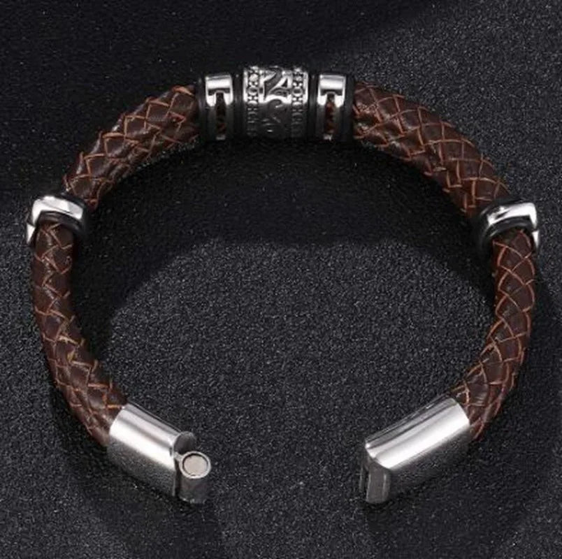 Brown braided leather bracelet with silver metal accents on a black background
