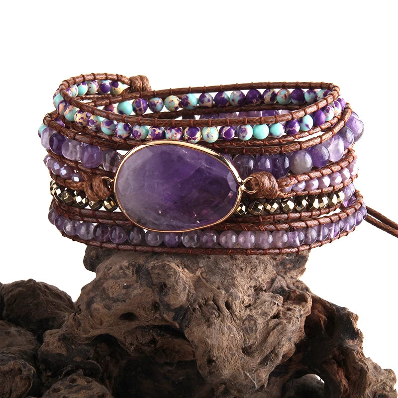 Multistrand beaded bracelet with a large purple stone on a natural wood background