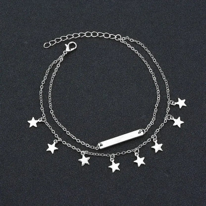 Silver bracelet with star charms on a dark background