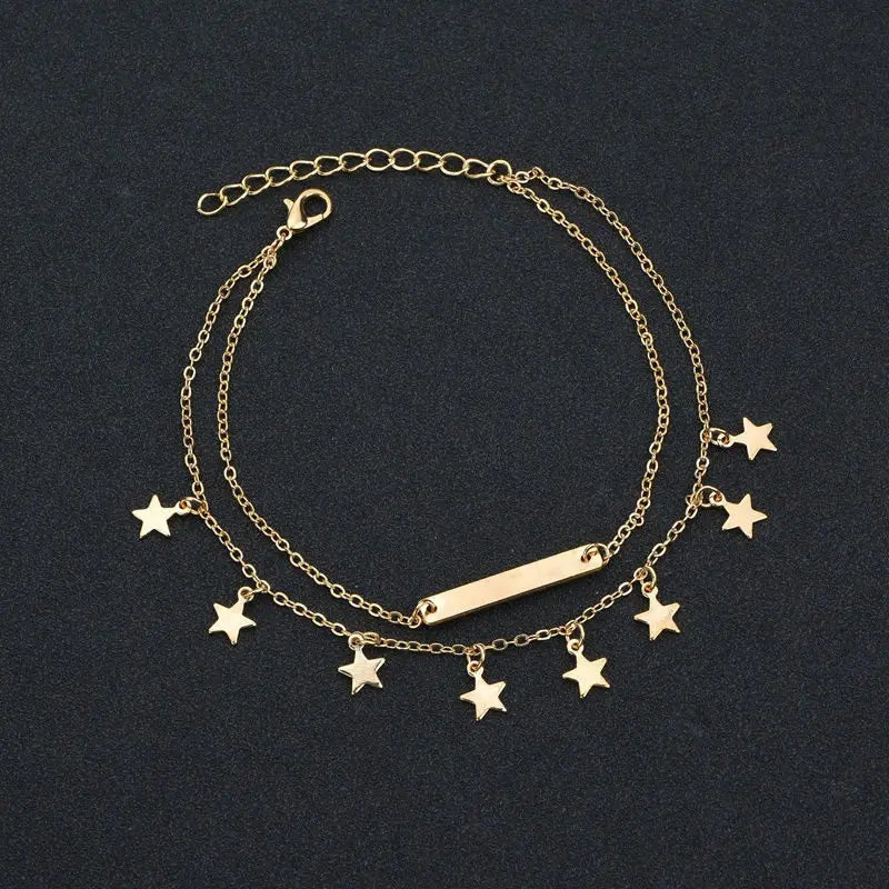 Gold bracelet with star charms on a black background