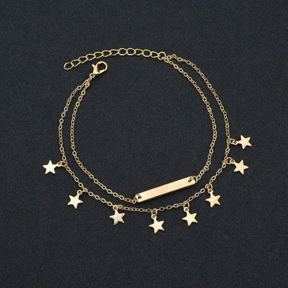 Gold bracelet with star charms on a black background