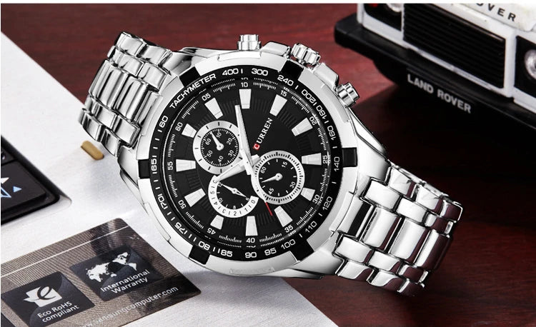 Silver wristwatch with black dial on a wooden surface