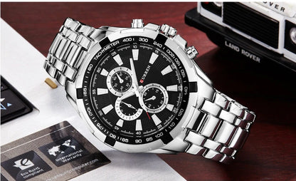Silver wristwatch with black dial on a wooden surface