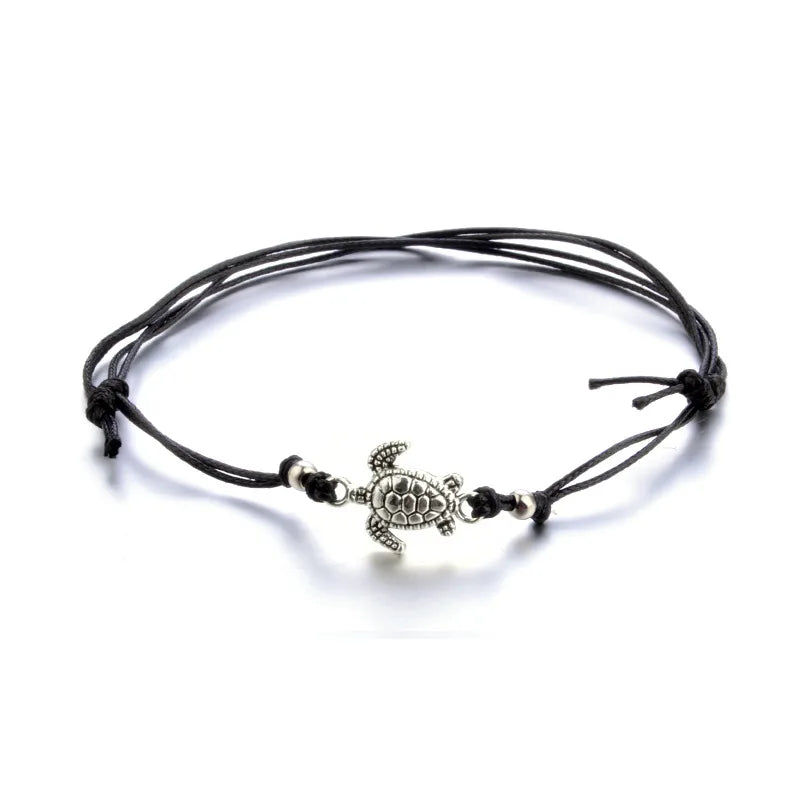 Black cord bracelet with a turtle charm on a white background