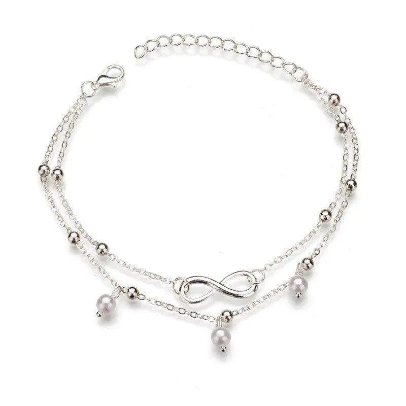 Silver anklet with pearls and an infinity symbol on a white background