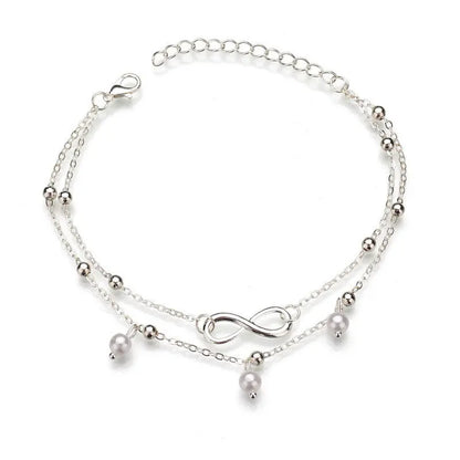 Silver anklet with pearls and an infinity symbol on a white background