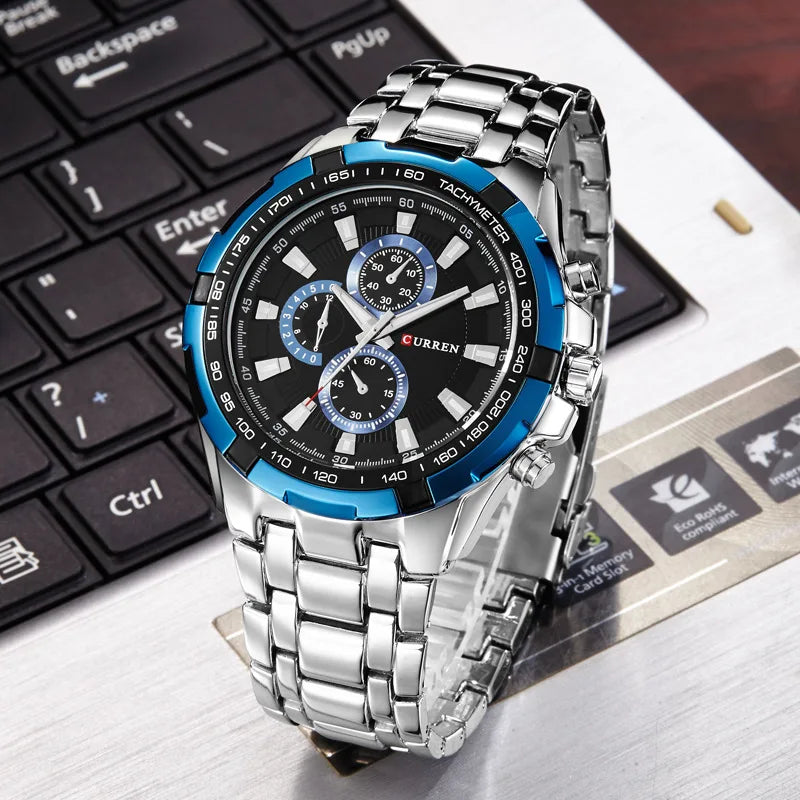 Silver and blue watch on a keyboard with visible brand name
