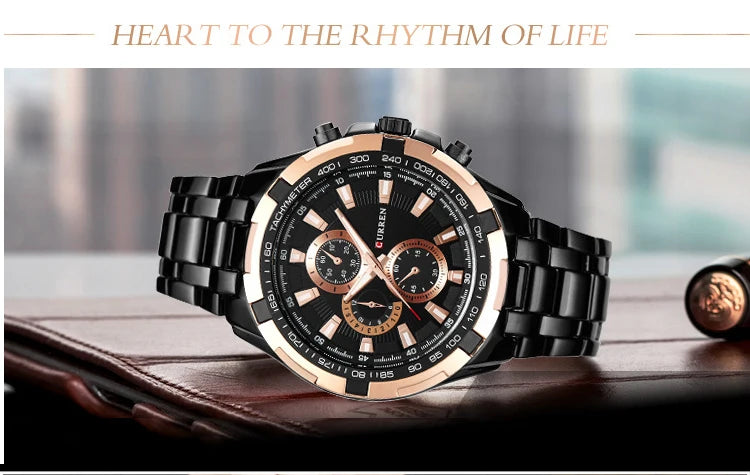 Luxury watch with black and rose gold design on a wooden surface, text 'Heart to the Rhythm of Life' above.