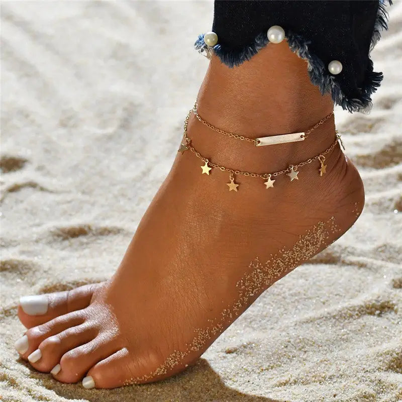Ankle with gold anklets on a sandy background