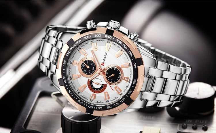 Silver and rose gold watch with a detailed face on a blurred background
