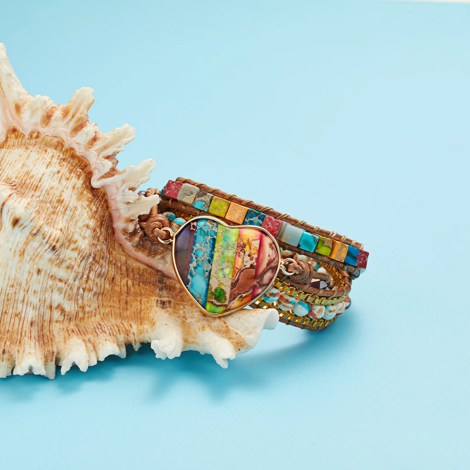 Colorful beaded bracelet on a large shell against a light blue background