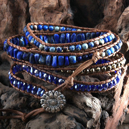 Stack of blue beaded bracelets with brown leather straps on a rustic wooden background