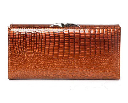 Brown crocodile-patterned clutch bag on a white background