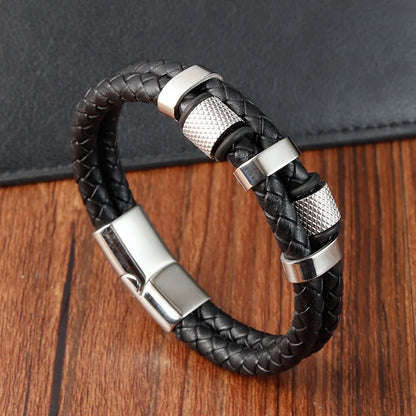 Black braided leather bracelet with silver metal accents on a wooden surface
