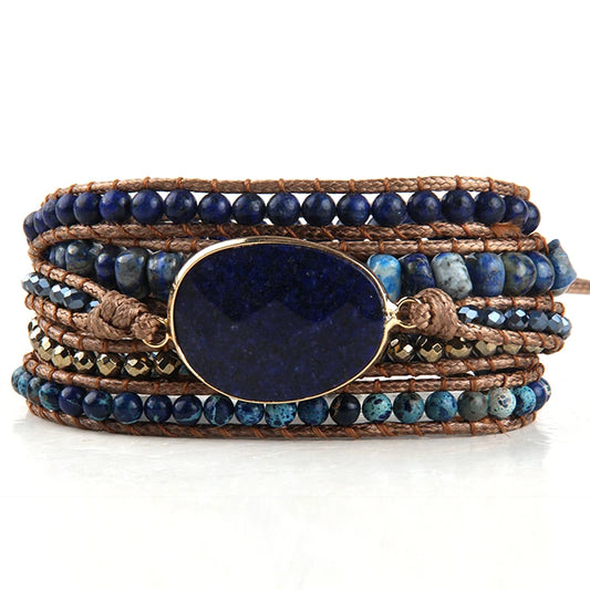 Multistrand bracelet with blue beads and a large blue stone on a white background
