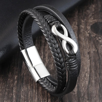Black braided leather bracelet with silver clasp on a wooden surface