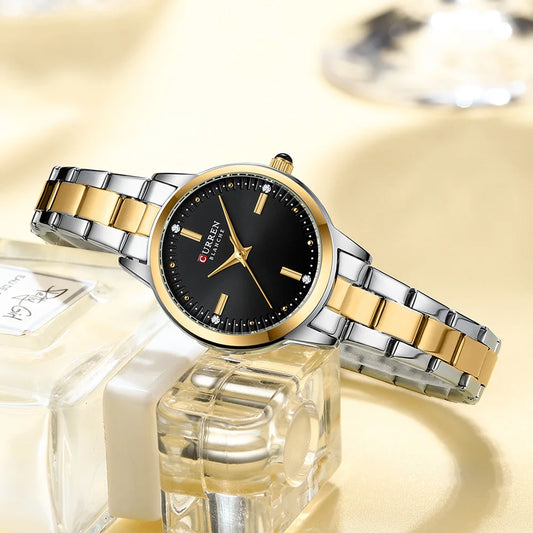 Luxury watch with gold and silver band on a reflective surface