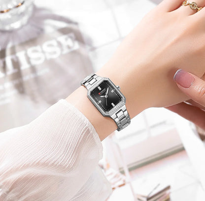Silver wristwatch on a person's wrist with a blurred background