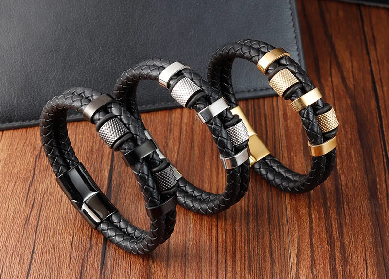 Three braided leather bracelets with metal accents on a wooden surface