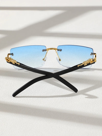 Sunglasses with black and gold frame and blue gradient lenses on a light background