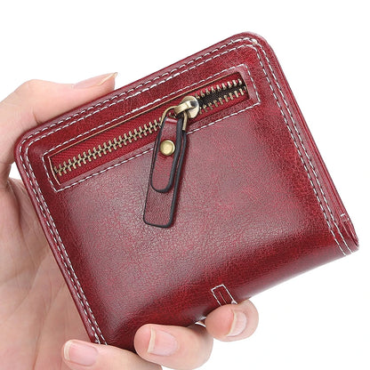 Red leather wallet with a zipper held by a hand on a white background
